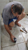 Hombre localizando una fuga de agua en el piso con el Detector de Fugas 2.0